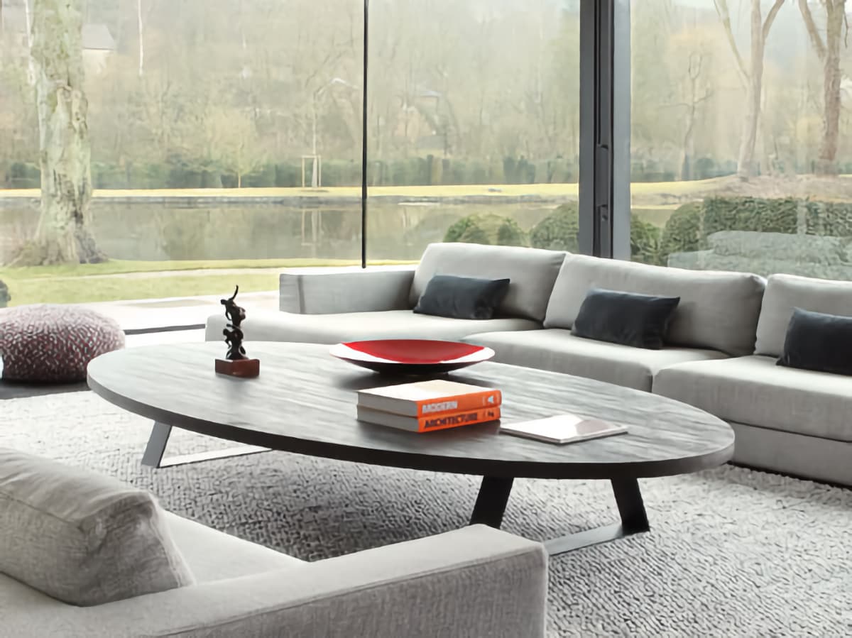 Table basse ovale installée devant un canapé dans un salon